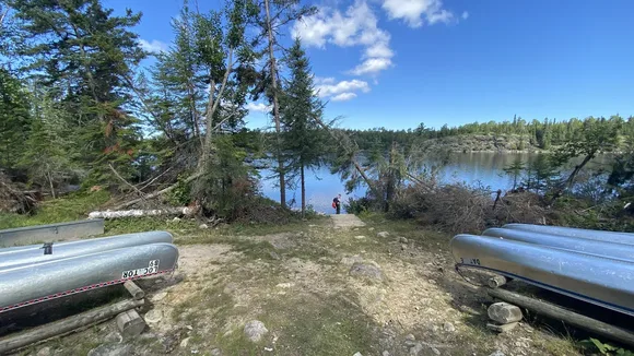 Canoe launch area with two rack of canoes and Locator Lake in background.